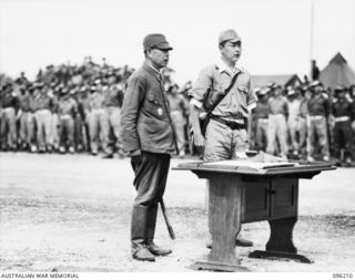CAPE WOM, NEW GUINEA, 1945-09-13. LIEUTENANT-GENERAL H. ADACHI, COMMANDER 18 JAPANESE ARMY IN NEW GUINEA, AND INTERPRETER, AT THE TABLE USED FOR THE SIGNING OF THE INSTRUMENT OF SURRENDER. ..