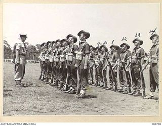 WONDECLA, ATHERTON TABLELAND, QLD. 1945-01-19. MAJOR RANSOME, ATTACHED 20 INFANTRY BRIGADE, (1), INSPECTS A PLATOON FROM 2/2 PIONEER BATTALION, 2 BEACH GROUP. THE MEN ARE PARTICIPATING IN THE ..