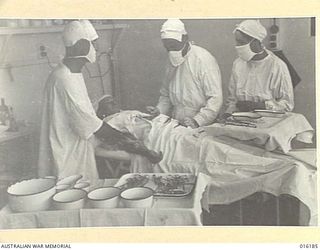 NEW GUINEA. 1943-11-22. AT AN AUSTRALIAN FIELD HOSPITAL DOCTORS IN THEATRE OPERATE ON A PATIENT