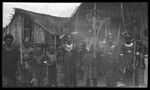 Goaribari men and boys outside houses; some men are wearing kina, a crescent shell valuable necklace