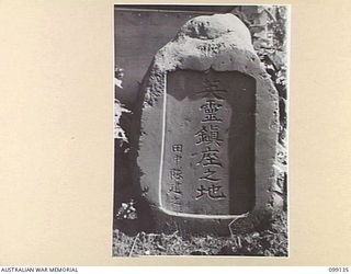 LAE, NEW GUINEA. 1945-11-3. THIS JAPANESE TOMBSTONE, NOW AT THE OFFICE OF THE DEPUTY ASSISTANT DIRECTOR WAR GRAVES, LAE, WAS DISCOVERED WHEN ONE OF THE SERGEANTS MESSES WAS BEING ERECTED. IT IS ..