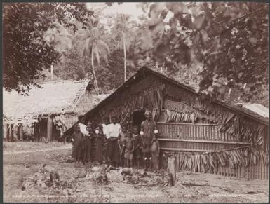 Three generations of a family standing in front of a village building, Solomon Islands, 1906 / J.W. Beattie