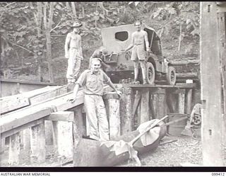 RABAUL, NEW BRITAIN, 1945-12-12. WORKSHOP PERSONNEL OF 11 DIVISION TRANSPORT SECTION WITH A JEEP ON THE REPAIR RAMP