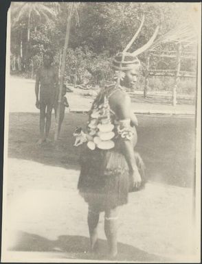 Woman with shell plates hanging down her back at standing in profile, Sepik River, New Guinea, 1935 / Sarah Chinnery
