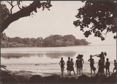 Ni-Vanuatu children on beach at Mota Lava lagoon and Ara in background, Banks Islands, 1906 / J.W. Beattie