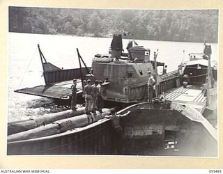 NANTAMBU, NEW BRITAIN, 1945-08-22. BARGES OF 53 PORT CRAFT COMPANY, ROYAL AUSTRALIAN ENGINEERS, MOORED NEAR THE WRECKED JAPANESE BARGE IN FOREGROUND. THESE BARGES AND CREWS WILL GO LATER BY SEA TO ..