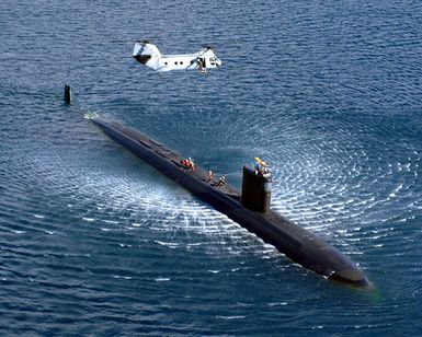 US Navy (USN) Sailors aboard an unidentified USN LOS ANGELES CLASS: Attack Submarine conduct Emergency Personnel Transfer Hoist Training with a USN CH-46 Sea Knight Helicopter from Helicopter Combat Support Squadron Five (HC-5) in Apra Harbor, Guam