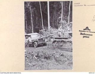 WEWAK AREA, NEW GUINEA, 1945-06-14. GENERAL SIR THOMAS A. BLAMEY, COMMANDER-IN-CHIEF, ALLIED LAND FORCES, SOUTH WEST PACIFIC AREA (1), IN A JEEP BEING TOWED BY A TRACTOR, UP A TORTUOUS HILL ON THE ..