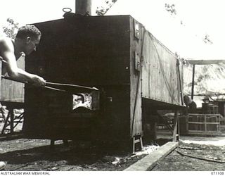 A member of the 8 Australian Field Baking Platoon (Charlie West?) firing the ovens. A mixture of oil (distillate) and water makes effective fuel