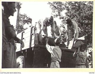 SORAKEN, BOUGAINVILLE, 1945-09-17. JAPANESE TROOPS UNLOADING RATIONS FROM A 3-TON AUSTRALIAN TRUCK. THEY LOADED SEVEN TONS OF SUPPLIES ONTO TWO JAPANESE BARGES FOR TRANSPORT AND DISTRIBUTION TO ..