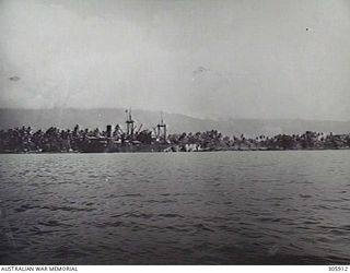 MILNE BAY, PAPUA. 1943. VIEW OF THE HARBOUR WITH THE DUTCH TRANSPORT BANTAM BERTHED ALONGSIDE THE WRECK OF THE ANSHUN, SUNK BY JAPANESE NAVAL UNITS DURING THE BATTLE OF MILNE BAY IN 1942-09. THE ..