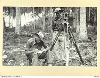 MILILAT, NEW GUINEA. 1944-07-22. NX108267 GUNNER J.W.F. BELL (1) AND NX95251 BOMBARDIER K.L. LUTHERBORROW (2) OF THE 5TH SURVEY BATTERY, SURVEYING THE MILILAT SECTION OF THE MADANG-ALEXISHAFEN ROAD