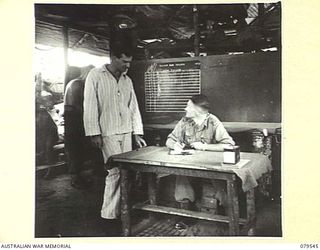 ORO BAY, NEW GUINEA. 1943-07. NX104013 MAJOR I.A. WILSON, OBTAINING PARTICULARS FROM A PATIENT IN THE COMBINED REGIMENTAL AID POST AND THE ADMISSION CENTRE OF THE 10TH FIELD AMBULANCE