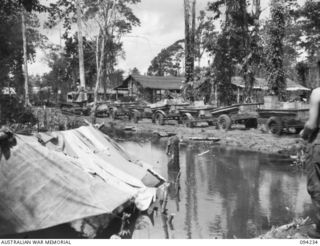 SOUTH BOUGAINVILLE. 1945-07-21. A TRACTOR TRAIN CARRYING SUPPLIES TO FORWARD TROOPS WEST OF THE MIVO RIVER, PASSES THE FLOODED 58/59 INFANTRY BATTALION CAMP SITE WEST OF THE OGORATA RIVER. THE ..