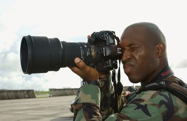 US Air Force (USAF) STAFF Sergeant (SSGT) DeNoris A. Mickle, Photographer, 36th Communication Squadron (CS), uses a Nikkor 300mm f/2.8 lens and a Nikon D1 digital camera to document the Exercise COPE NORTH on Andersen Air Force Base (AFB), Guam