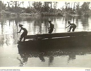 MOTUPENA POINT, BOUGAINVILLE ISLAND, 1945-01-26. SAPPERS OF THE 23RD FIELD COMPANY FERRYING PILES OUT TO THE SITE OF THE NEW PERMANENT BRIDGE WHICH THE UNIT IS BUILDING ACROSS THE JABA RIVER