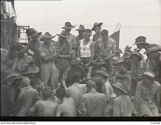 AT SEA IN ADMIRALTY ISLANDS AREA. 1944-03-08. A MEDICAL OFFICER, FLIGHT LIEUTENANT R. C. WILLIS, MELBOURNE, VIC, IS GIVING A TALK ON TROPICAL HYGIENE TO RAAF REINFORCEMENT TROOPS ON A LANDING CRAFT ..