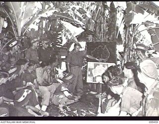 RABAUL, NEW BRITAIN, 1945-12-17. A DISCUSSION GROUP ORGANISED BY THE UNIT EDUCATION OFFICER, IN PROGRESS UNDER THE BANANA TREES AT 22ND INFANTRY BATTALION