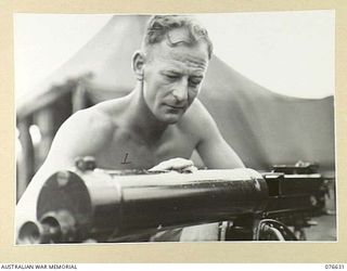 LAE, NEW GUINEA. 1944-10-27. VX117519 PRIVATE J.H. BROWNING, HEADQUARTERS COMPANY, 14/32ND INFANTRY BATTALION CLEANING THE BARREL OF HIS VICKERS GUN