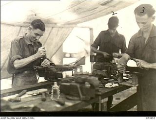 Madang, New Guinea. 1944-06-14. The armoury at the 266th Light Aid Detachment, Headquarters 15th Infantry Brigade. The unit is located at Siar Plantation. Left to right: QX5000 Craftsman A. F. ..