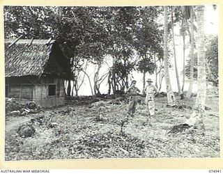 FINSCHHAFEN, NEW GUINEA. 1944-07-31. TX6288 LIEUTENANT M. WILSON (1) AND NX142659 MAJOR E.S. COX (2) OF THE 19TH LINES OF COMMUNICATION SIGNALS IN THE CLEARING OF THE OLD SIGNAL CAMP