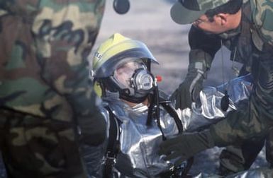 MASTER Sergeant (MSGT) Delbert Ferrin, deputy fire chief, Hickam Air Force Base, Hawaii, is checked by competition judges after completing the search and rescue phase of Exercise READINESS CHALLENGE 87. Ferrin is wearing a proximity suit