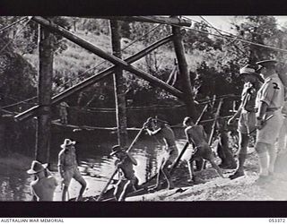 DONADABU, SOGERI VALLEY, NEW GUINEA. 1943-06-30. TROOPS OF THE PIONEER PLATOON, 9TH AUSTRALIAN INFANTRY BATTALION, 7TH AUSTRALIAN INFANTRY BRIGADE, WITH BRIDGE TRESTLE IN POSITION. SEEN ARE: ..