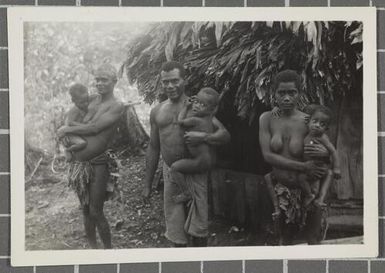 Group of people outside a hut, Nissan