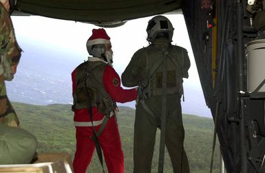 US Air Force (USAF) Colonel (COL) Paul G. Schafer, the 355th Wing Commander (WC) dressed as Santa Claus on the open cargo ramp of a US Air Force (USAF) C-130 Hercules from Yokota Air Base (AB), Japan, during the first flight of the 50th anniversary Christmas Drop