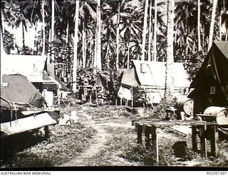 Astrolabe Bay, Madang, New Guinea, 1945-08. 'Frog 'Ollow', a nickname for part of the officers' lines at Headquarters, RAAF Northern Command (NORCOM). A narrow pathway runs between tents occupied ..