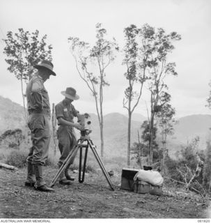 MR GEORGE HEATH (1) CHIEF CAMERAMAN OF CHAUVEL'S PRODUCTIONS SETTING UP HIS CAMERA AT OWERS' CORNER ON THE KOKODA TRAIL IN THE OWEN STANLEY RANGES PREPARATORY TO SHOOTING FILM SEQUENCES FOR THE ..