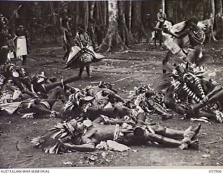 DOBODURA, NEW GUINEA. 1943-10-10. NATIVE CEREMONIAL DANCES IN PROGRESS IN THE VILLAGE CLEARING WERE ATTENDED BY ALLIED TROOPS AND NURSES