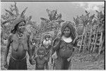 Bride price ritual: bride (wearing large shell valuables) walks behind other women