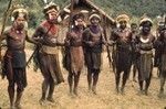 Decorated men practice dancing and chanting in advance of a ceremony