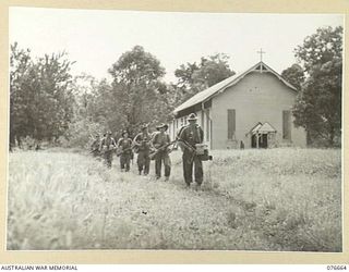 JACQUINOT BAY, NEW BRITAIN. 1944-11-04. MEMBERS OF A COMPANY HEADQUARTERS PATROL OF THE 14/32ND INFANTRY BATTALION LEAVING THE MALMAL MISSION CHURCH TO CHECK ON THE FORWARD POSITIONS