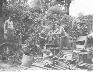 BOUGAINVILLE ISLAND. 1945-03-01. PERSONNEL OF THE 9TH INFANTRY BATTALION LOADING THE UNIT STORES AND EQUIPMENT ON A TRAILER OF A TRACTOR CONVOY IN PREPARATION FOR THE UNIT MOVE ALONG THE MOISGETTA ..