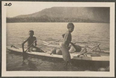 Two Papuan boys in a canoe with coconuts, Rabaul, New Britain Island, Papua New Guinea, approximately 1916