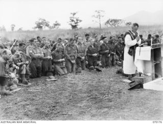 DUMPU, NEW GUINEA. 1944-02-06. QX19123 CHAPLAIN J.B. LYNCH (ROMAN CATHOLIC) (1), CONDUCTING THE REQUIEM MASS AT THE DUMPU WAR CEMETERY AFTER THE DEDICATION SERVICE