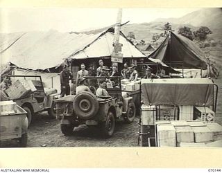 RAMU VALLEY, NEW GUINEA. 1944-02-04. UNIT REPRESENTATIVES AT THE AUSTRALIAN ARMY CANTEENS SERVICE ISSUING-POINT, DUMPU, ORDERING AND COLLECTING SUPPLIES. IDENTIFIED PERSONNEL ARE:- SERGEANT J. ..