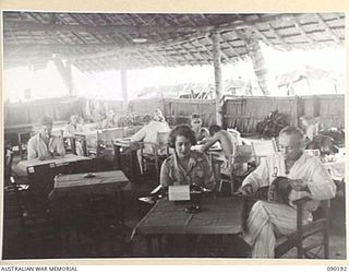 AITAPE, NEW GUINEA. 1945-03-29. SUPERINTENDENT B. BROWN, RED CROSS SOCIETY WORKER (1), AMONG LIBERATED PRISONERS OF WAR IN THE RED CROSS HUT AT 104 CASUALTY CLEARING STATION. THE MEN ARE ..