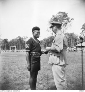 LAE, NEW GUINEA. 1944-09-09. VX13 LIEUTENANT-GENERAL S.G. SAVIGE, CB, CBE, DSO, MC, ED, GOC, NEW GUINEA FORCE (1) INVESTING 3233 SERGEANT MERIRE, ROYAL PAPUAN CONSTABULARY (2) WITH THE BRITISH ..