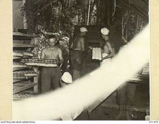 GUY'S POST, RAMU VALLEY, NEW GUINEA, 1944-03-27. AN AUSTRALIAN FIELD BAKERY WORKING AT GUY'S POST. THIS BAKERY, WITH ITS STAFF OF TEN PRODUCES 6,000 BUNS PER DAY. SHOWN ARE: V45801 PRIVATE A.E. ..