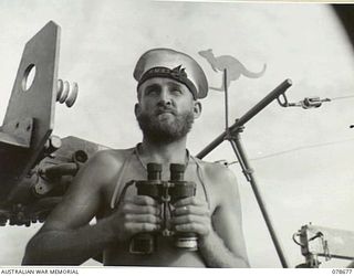 AT SEA. 1945-01-28. ABLE SEAMAN J. CONWAY ON WATCH ABOARD THE ML802 AT THE ROYAL AUSTRALIAN NAVY PORT DIRECTORAE, JACQUINOT BAY