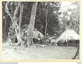 SAMPUN, NEW BRITAIN. 1945-01-15. MEMBERS OF THE ALLIED INTELLIGENCE BUREAU PATROL INTERROGATING NATIVE WOMEN OF THE SAMILON VILLAGE