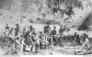 ROUNA FALLS, PAPUA, 1942-05. SPOTTERS FROM THE NEW GUINEA AIR WARNING WIRELESS COMPANY (NGAWW) READ THEIR MAIL, SITTING IN A CLEARING