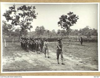 POM POM VALLEY, NEW GUINEA. 1943-11-30. A COMPANY, 2/12TH AUSTRALIAN INFANTRY BATTALION, ADVANCING IN "COLUMN OF ROUTE" AS THEY MARCH OFF THE SPORTSGROUND. IDENTIFIED PERSONNEL ARE: QX37666 ..