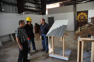 Hazard Mitigation Specialist Mario Verde discussing with NMTI's Mike Vargas and ACE Hardware Store Manager Ramon Sablan, the mitigation techniques used on the models.