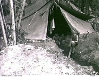 THE SOLOMON ISLANDS, 1945-04-24/27. THREE AUSTRALIAN SERVICEMEN NEAR THE ENTRANCE TO THEIR TENT WITH A DEEP FLOOR ON BOUGAINVILLE ISLAND. (RNZAF OFFICIAL PHOTOGRAPH.)