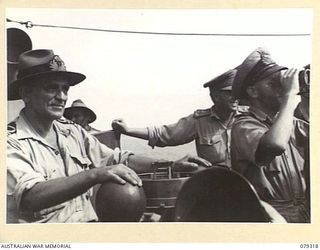 BUT AREA, NEW GUINEA. 1945-02-26. LIEUTENANT W.J. DOVERS, RAN, SKIPPER OF THE HMAS "SWAN" SEARCHING THE TARGET AREA DURING THE BOMBARDMENT OF THE JAPANESE POSITIONS IN THE BUT- KUAK AREA BETWEEN ..