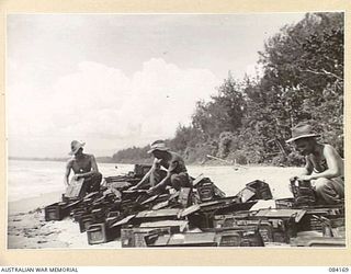 BOUGAINVILLE, SOLOMON ISLANDS. 1944-12-09. D TROOP, 5 FIELD BATTERY, 2 FIELD REGIMENT ARTILLERYMEN DRYING AMMUNITION BOXES ON THE BEACH. THE BOXES HAD BEEN SWAMPED IN A BARGE DURING THE LANDING. ..
